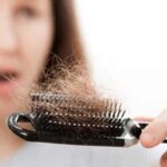 Women holding a brush containing a large amount of hair