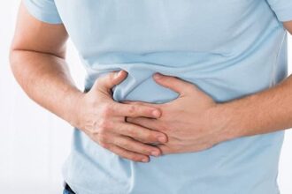 A man clutching his stomach with digestive pain