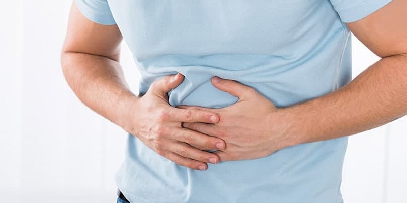 A man clutching his stomach with digestive pain