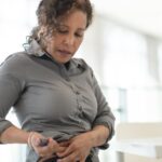 Image of a women injecting a medication pen into her stomach