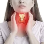 Woman holding her throat and showing  where her thyroid is