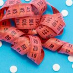 A measuring tape and pills lying on a table