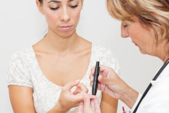 Doctor testing patient for diabetes with a fingerstick test