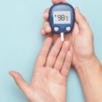 Close up of hands using a blood sugar monitor