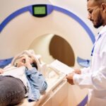 Doctor stands next to patient in an MRI device