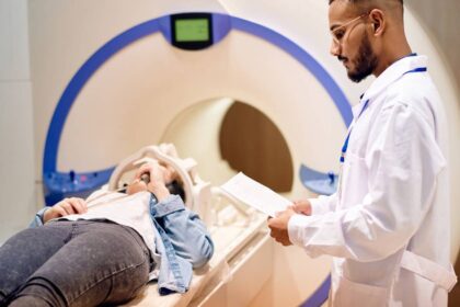 Doctor stands next to patient in an MRI device