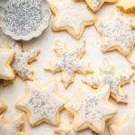 Multiple gluten free sugar cookies decorated with icing and sprinkles.